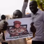 Nigeriens participate in a march called by supporters of coup leader Gen. Abdourahmane Tchiani, pictured, in Niamey, Niger, on July 30. Photo: Sam Mednick/Associated Press.