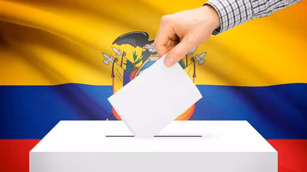 A hand inserts a ballot into a ballot box, with the flag of Ecuador in the background. File photo.
