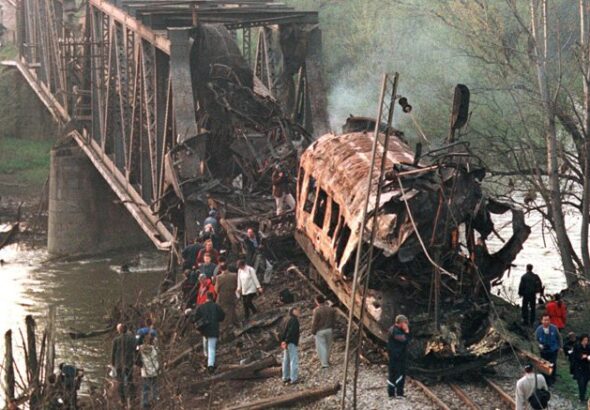 The smoldering wreckage of a passenger train after being hit by two missiles launched from a NATO F-15. At least 55 commuters were killed. Photo: Struggle La Lucha/File photo.
