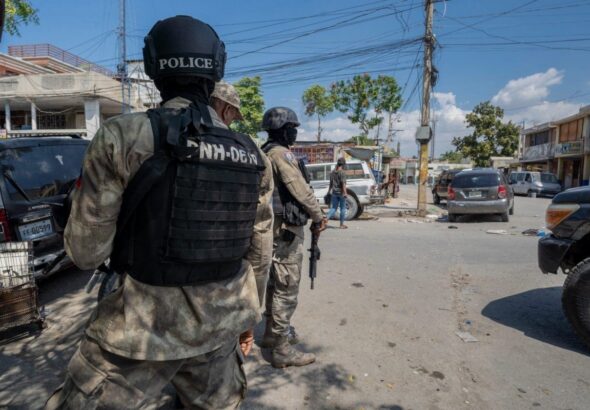 Police officers patrol a street in the Haitian capital of Port-au-Prince. Photo: Marvens Compère/Haitian Times.