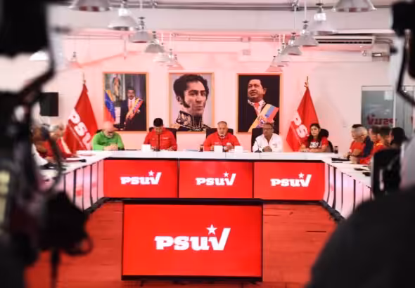 Cabello and PSUV members seated in front of portraits of Simón Bolívar and Hugo Chávez. File photo.