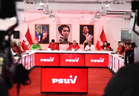 Cabello and PSUV members seated in front of portraits of Simón Bolívar and Hugo Chávez. File photo.