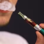 A person smoking an e-cigarette. File photo.