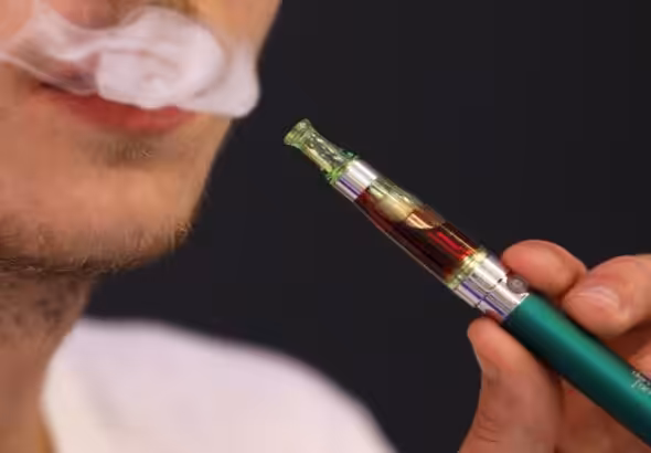 A person smoking an e-cigarette. File photo.