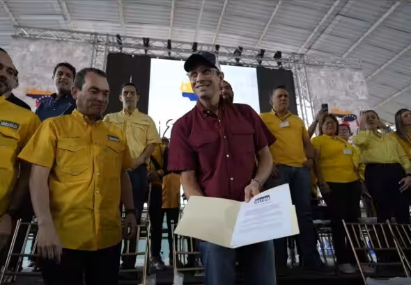 Justice First (PJ) party leader Henrique Capriles attending a party event, sharing a document identifying himself as the party's candidate for the opposition primaries. Photo: Ariana Cubillos/Associated Press/File photo.