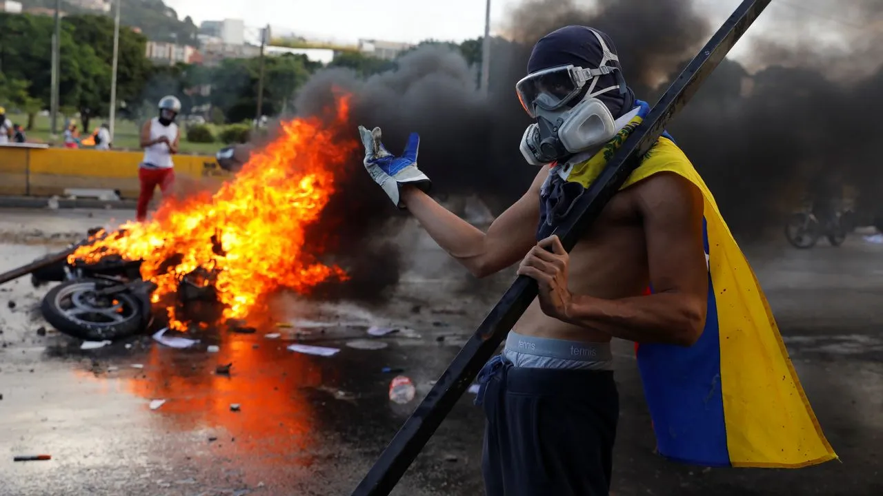 Venezuelan right-wing violent protestors posing after burning a police motorcycle during the 2019 guarimbas in east Caracas: Photo: RIA Novosti/File photo.