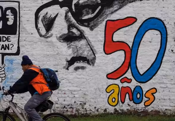 A man pedals his bicycle past a mural marking the 50th anniversary of the country's military coup, with a reminder of those disappeared during the Augusto Pinochet regime and an image depicting the deposed President Salvador Allende, in Santiago, Chile, Friday, September 8, 2023. Photo: Morning Star/File photo.