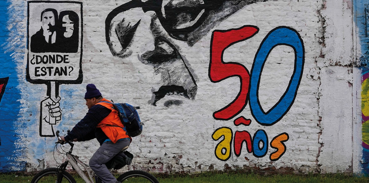A man pedals his bicycle past a mural marking the 50th anniversary of the country's military coup, with a reminder of those disappeared during the Augusto Pinochet regime and an image depicting the deposed President Salvador Allende, in Santiago, Chile, Friday, September 8, 2023. Photo: Morning Star/File photo.