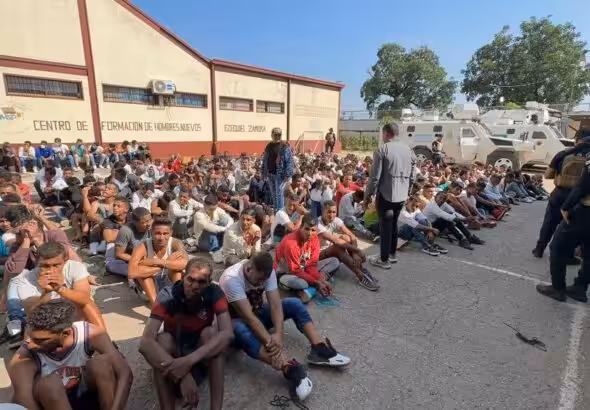 Tocorón Prison inmates seated on the ground while being guarded by law enforcement agents. Photo: X/@NicolásMaduro.