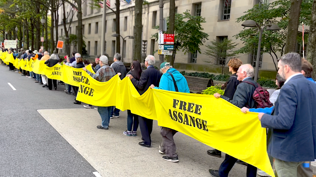 Assange supporters in October 2022 carry yellow ribbon around the US Justice Department Building, demanding freedom for Julian Assange. Photo: Joe Lauria.
