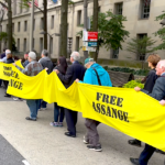 Assange supporters in October 2022 carry yellow ribbon around the US Justice Department Building, demanding freedom for Julian Assange. Photo: Joe Lauria.