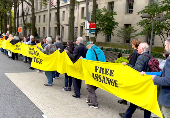 Assange supporters in October 2022 carry yellow ribbon around the US Justice Department Building, demanding freedom for Julian Assange. Photo: Joe Lauria.