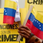 Venezuelans marching, holding a banner saying "Sanctions Are A Crime." Photo: File photo.