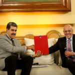 Venezuelan President Nicolás Maduro (left) shaking hands with PSUV deputy Jorge Rodríguez (right), holding the agreements signed in Barbados and announcing to the Venezuelan people the US empire's decision to lift some of their illegal sanctions, at Miraflores Palace, Caracas, on Wednesday, October 18, 2023. Photo: EFE.