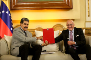 Venezuelan President Nicolás Maduro (left) shaking hands with PSUV deputy Jorge Rodríguez (right), holding the agreements signed in Barbados and announcing to the Venezuelan people the US empire's decision to lift some of their illegal sanctions, at Miraflores Palace, Caracas, on Wednesday, October 18, 2023. Photo: EFE.