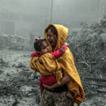 A woman holding a girl reacts after Israeli airstrikes hit Ridwan neighborhood of Gaza City, Gaza on October 23, 2023. Photo: Anadolu Images.