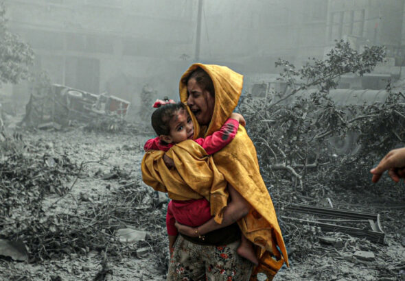 A woman holding a girl reacts after Israeli airstrikes hit Ridwan neighborhood of Gaza City, Gaza on October 23, 2023. Photo: Anadolu Images.