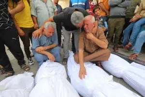 Palestinians mourn over the bodies of their loved ones who were killed in an Israeli airstrike in Deir al-Balah, central Gaza, October 27. Photo: Omar Ashtawy/APA Images.