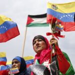 Palestinian women holding hand flags of Venezuela and Palestine during a ceremony celebrating the arrival of Palestinian students in Venezuela on June, 2014. Photo: Jorge Silva/Reuters/File photo.