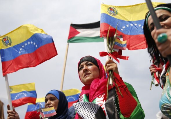 Palestinian women holding hand flags of Venezuela and Palestine during a ceremony celebrating the arrival of Palestinian students in Venezuela on June, 2014. Photo: Jorge Silva/Reuters/File photo.
