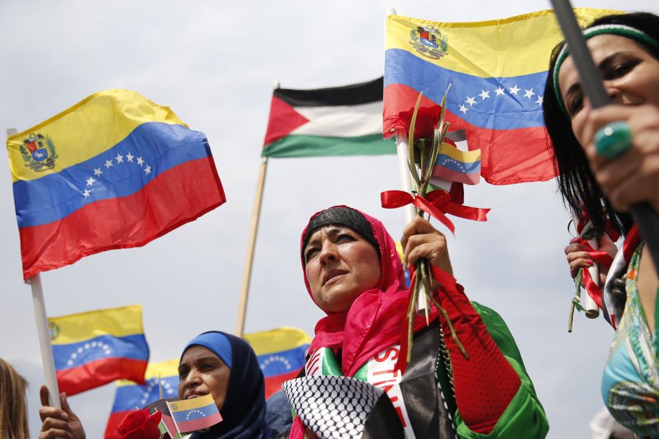 Palestinian women holding hand flags of Venezuela and Palestine during a ceremony celebrating the arrival of Palestinian students in Venezuela on June, 2014. Photo: Jorge Silva/Reuters/File photo.