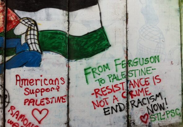 A mural on a wall depicting a person holding a Palestinian flag (left) and the following caption (right): “From Ferguson to Palestine, Resistance is not a crime, end racism now!” Photo: Sotwe.com/File photo.