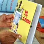 A person holding a literacy program book that says in Spanish "Yo, si puedo" and in English means "Yes, I can." Photo: Prensa Latina/File photo.
