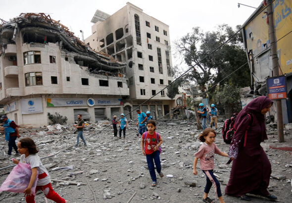 Residents move away for safer spots amid destroyed buildings and debris around the Palestinian Telecommunications Company, which was targeted, after Israeli airstrikes in Gaza Strip on October 10, 2023. Photo: Anadolu Agency.