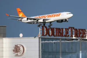 A Conviasa Airbus 340 jet in a landing approach, flying over a DoubleTree Hilton hotel. Photo: File photo.