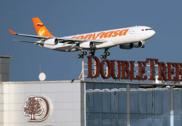 A Conviasa Airbus 340 jet in a landing approach, flying over a DoubleTree Hilton hotel. Photo: File photo.