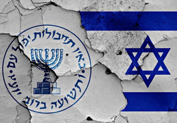 Logo of the Israeli intelligence agency Mossad and the Israeli flag painted on a cracked wall. Photo: Shutterstock.
