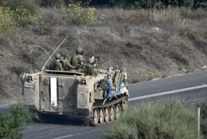 Israeli soldiers ride an armored vehicle along a road on the outskirts of the Gaza strip in occupied Palestine on October 28th. Photo: Aris Messinis/AFP.