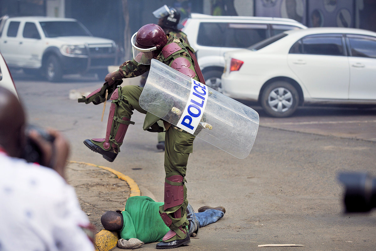 A Kenyan policeman stomping on a prone demonstrator in Nairobi in 2016. Credit: Ben Curtis/AP Photo.