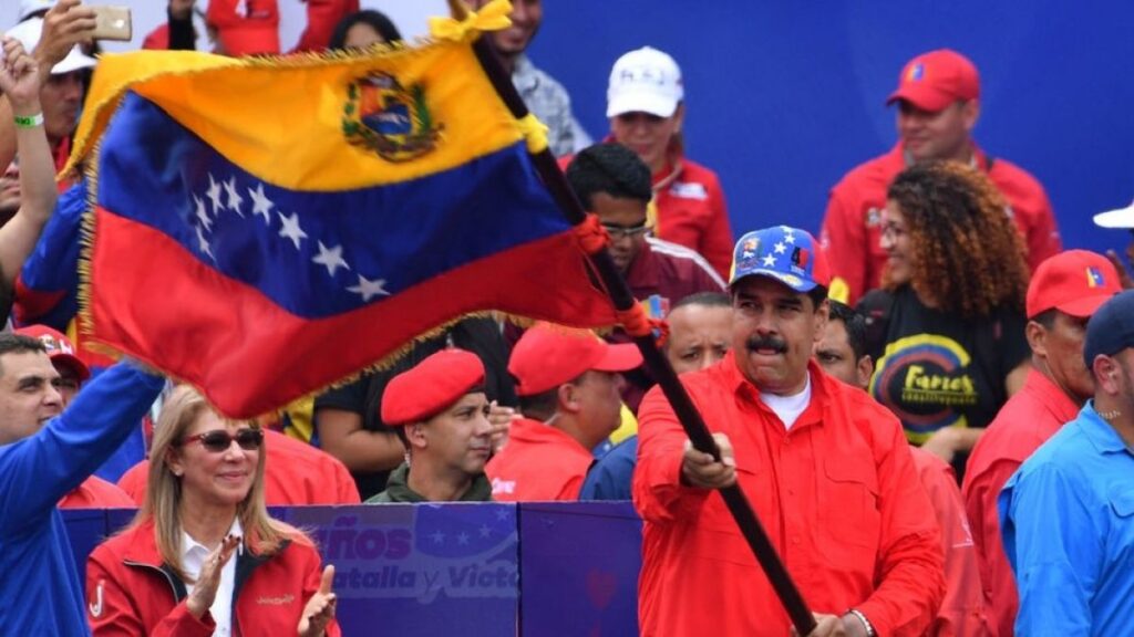 Venezuelan President Nicolás Maduro flies the national flag, accompanied by supporters. File photo.