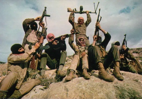 In the mountains east of the Jordan River, a patrol of Popular Front for the Liberation of Palestine fedayeen (freedom fighters) punctuates a battle hymn in early 1969. Photo: Thomas R. Koeniges/LOOK Magazine/File photo.