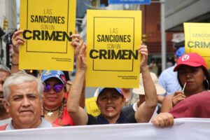 Venezuelans march in Caracas with posters that say "Sanctions are a crime." Photo: VTV.