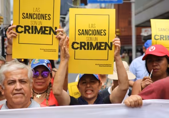 Venezuelans march in Caracas with posters that say "Sanctions are a crime." Photo: VTV.