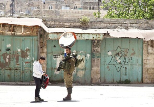 Photograph of an IDF soldier frisking a Palestinian child. Photo: Trocaire/Ireland.