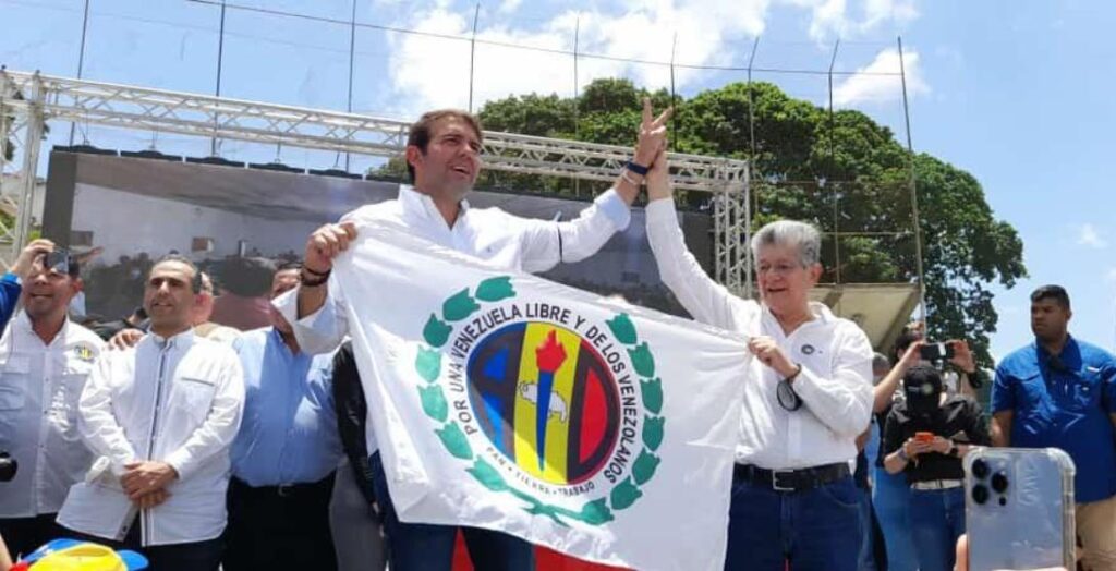 Democratic Action (AD) leader Henri Ramos Allup (right) raising the fist of Carlos Prosperi (left) while both hold an AD flag during the announcement of his appointment as opposition primaries pre-candidate on September 12, 2023. Photo: Notitarde/file photo.