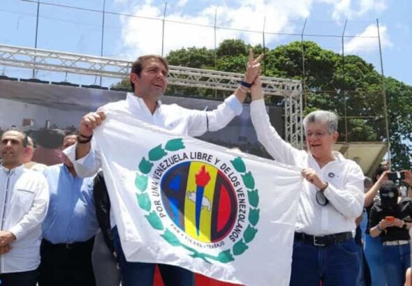 Democratic Action (AD) leader Henri Ramos Allup (right) raising the fist of Carlos Prosperi (left) while both hold an AD flag during the announcement of his appointment as opposition primaries pre-candidate on September 12, 2023. Photo: Notitarde/file photo.
