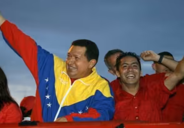 Former Venezuelan President Hugo Chávez (left) next to then-student leader Robert Serra (right) during a political rally. Photo: AFP/File photo.