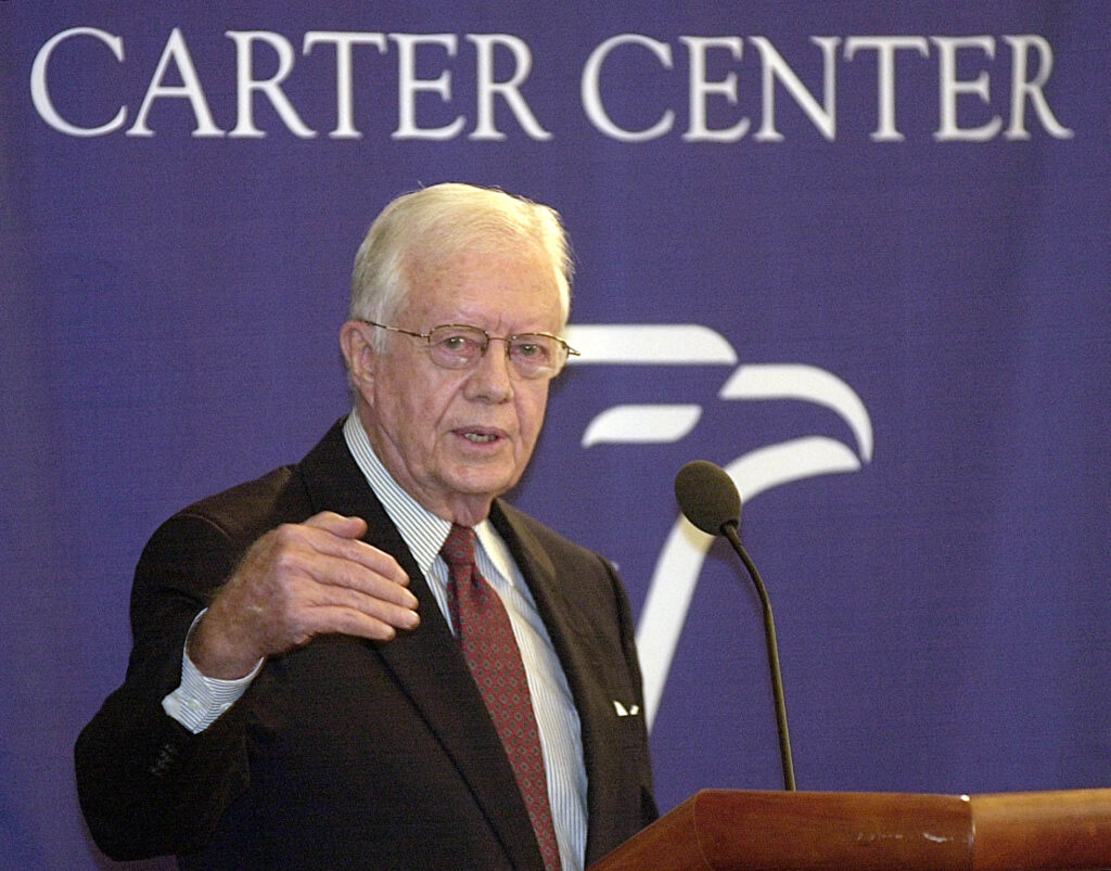Former president of the US empire and head of the Carter Center, Jimmy Carter, pictured during a conference with a banner in the background reading "Carter Center." Photo: Reuters/File photo.