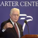 Former president of the US empire and head of the Carter Center, Jimmy Carter, pictured during a conference with a banner in the background reading "Carter Center." Photo: Reuters/File photo.