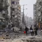 Palestinians walk through destruction in Al-Shati refugee camp on Saturday, Nov. 25, 2023 ceasefire. Photo: AP.
