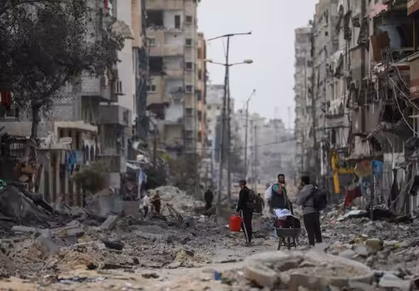 Palestinians walk through destruction in Al-Shati refugee camp on Saturday, Nov. 25, 2023 ceasefire. Photo: AP.
