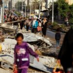 Displaced Palestinians walk along a road in Khan Younis, southern Gaza Strip, as they return to their homes after the start of the truce on November 24, 2023. Photo: Ibraheem Abu Mustafa/Reuters.