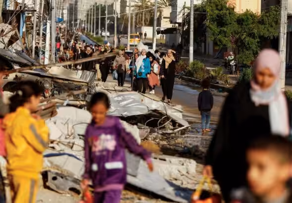 Displaced Palestinians walk along a road in Khan Younis, southern Gaza Strip, as they return to their homes after the start of the truce on November 24, 2023. Photo: Ibraheem Abu Mustafa/Reuters.