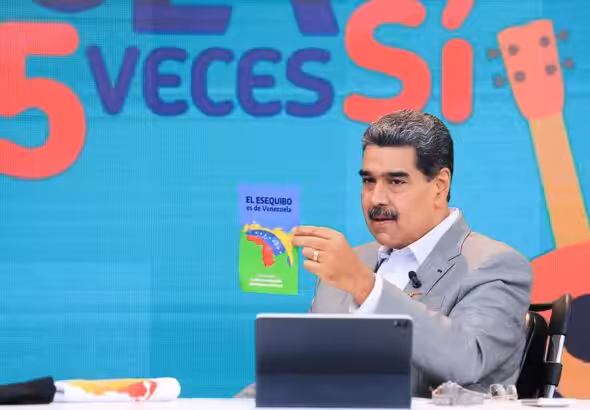 Venezuelan President Nicolás Maduro holds a pamphlet which reads "El Esequibo es de Venezuela," meaning "The Essequibo is Venezuela's."