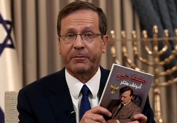 The president of the Israeli settler entity, Isaac Herzog, showing a copy of Hitler’s Main Kampf book in Arabic allegedly found in a raided house, in a pathetic attempt to justify the genocide his government is conducting against Palestinians in Gaza. Photo: BBC/File photo.