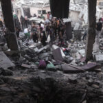 Palestinians look for survivors under the rubble of a destroyed house following an Israeli airstrike in Khan Younis refugee camp, southern Gaza Strip, on November 13, 2023. Photo: AP.